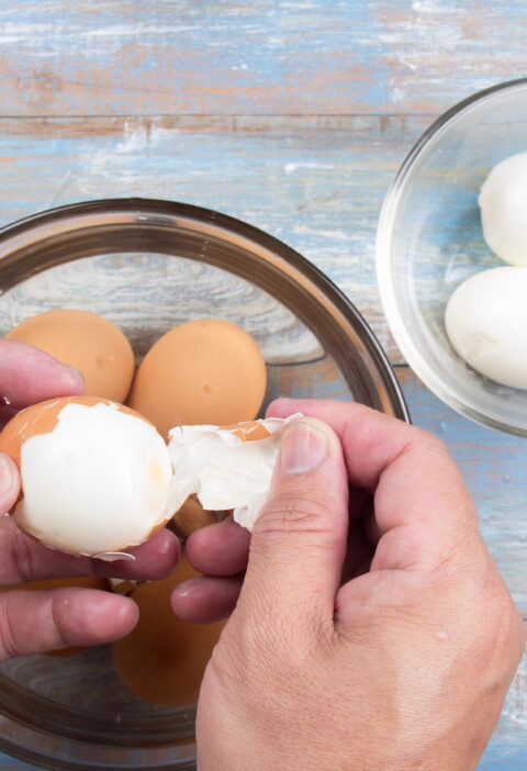 a person peeling eggs